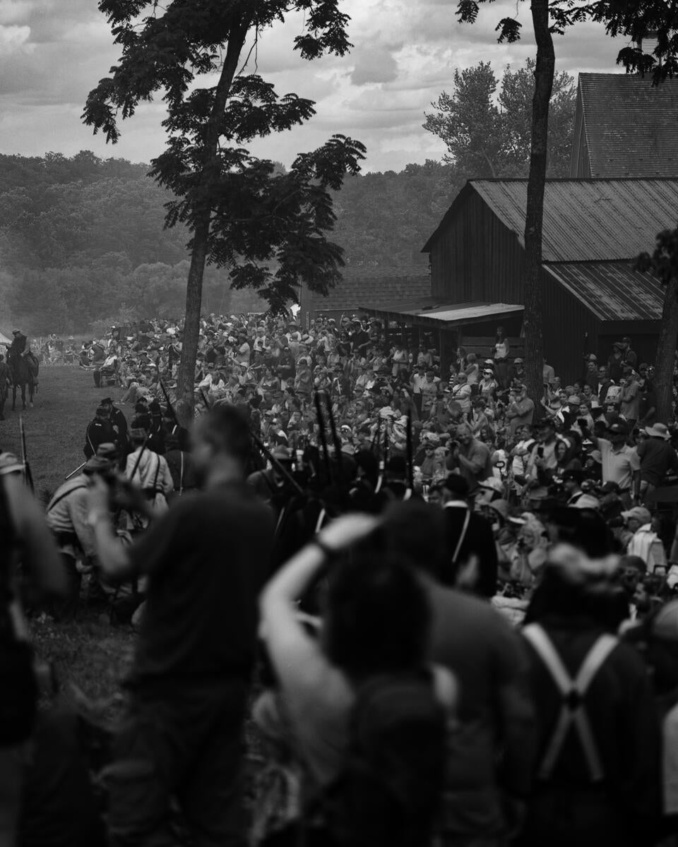 A smoky battle scene. It is hard to distinguish spectators from participants. 