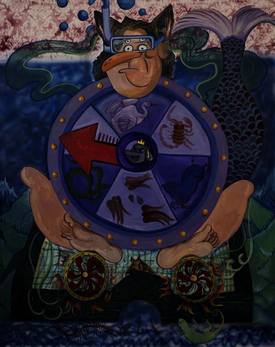A man with a spinning wheel sitting in a small city.
