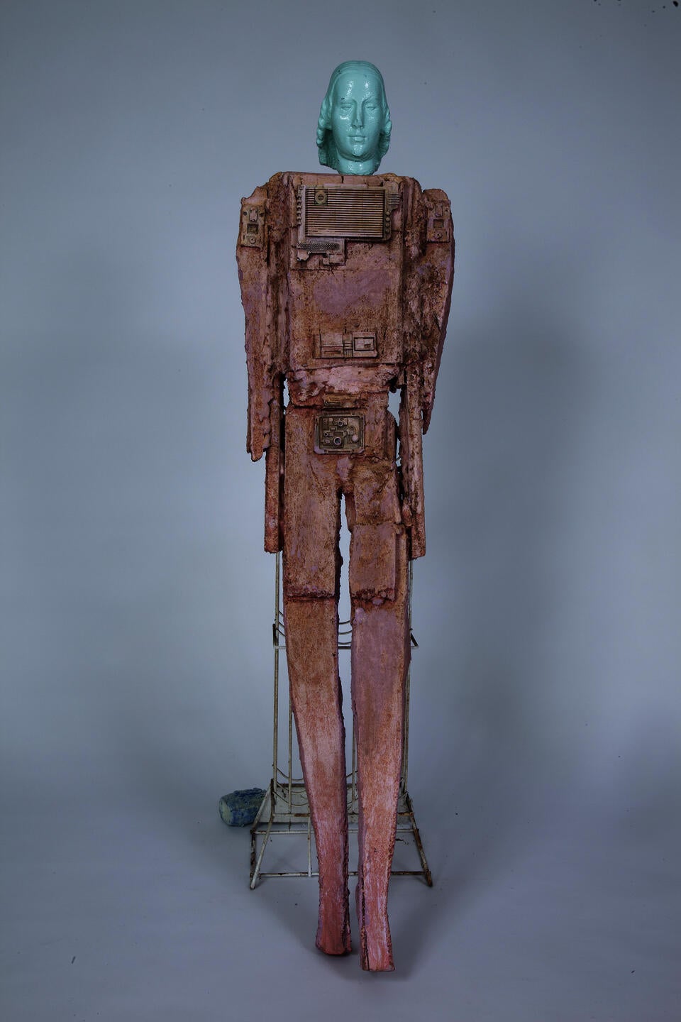 pink robotic figure leaning on wine rack