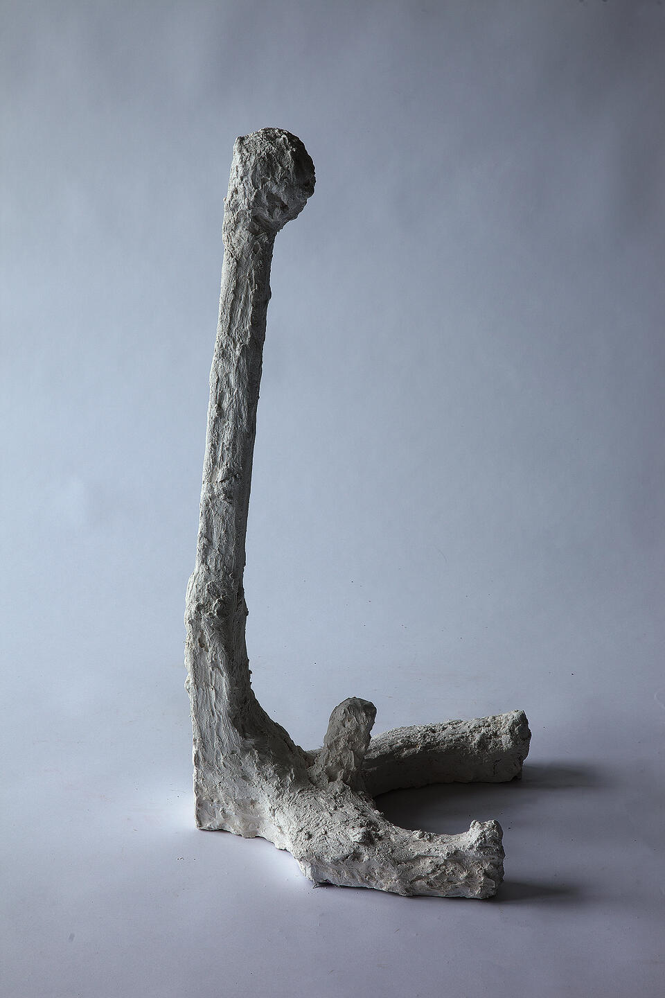 Plaster figure with a long neck and erect phallus