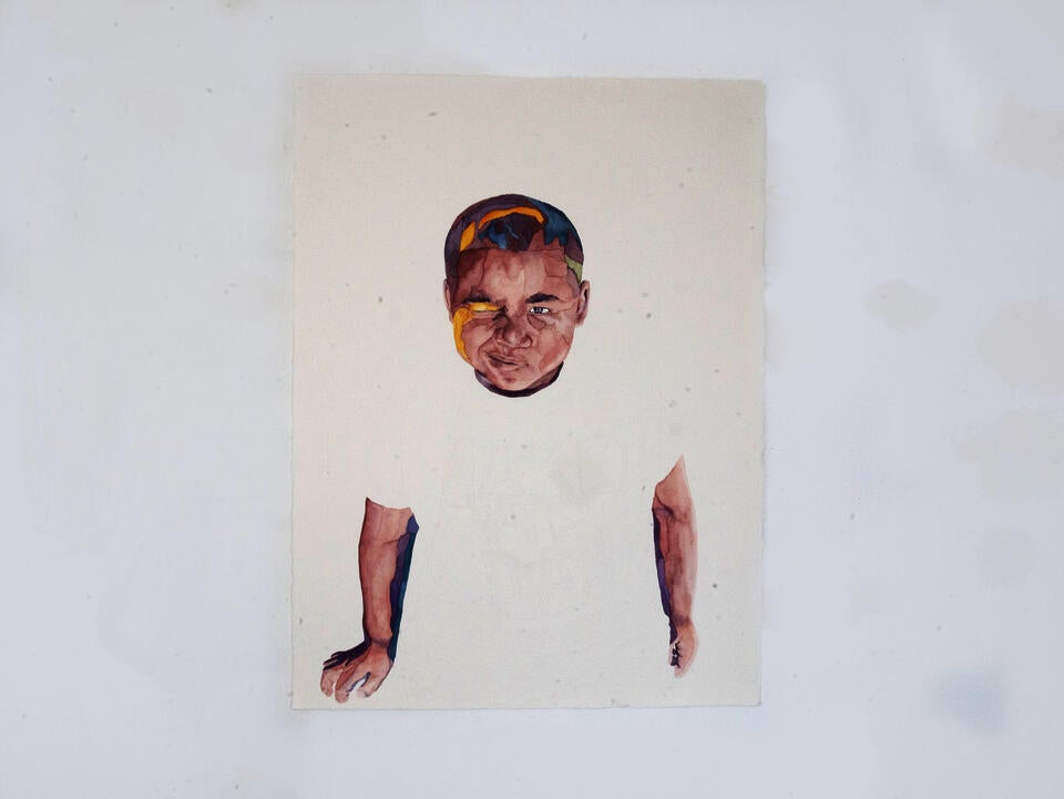 Portrait of a young boy making a winking face.
