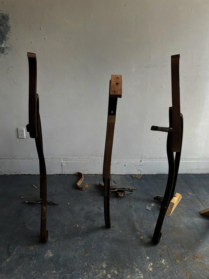 Pieces of old rocking chairs reconnected to stand straight up but crooked and bendy.