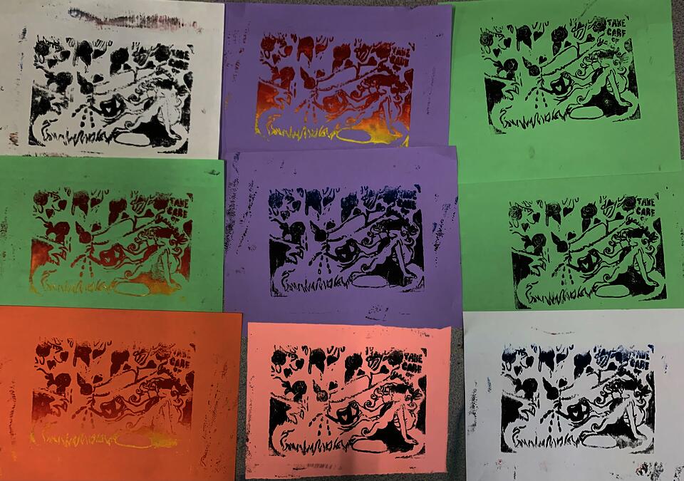 Various colored linocut blocks that have a girl watering a tree on them