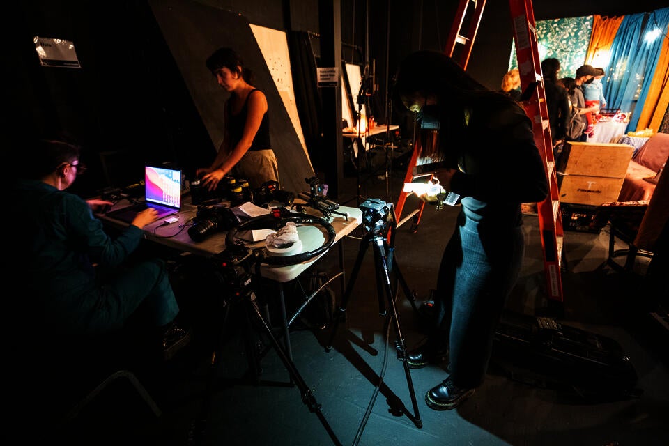 Surrounded by camera and lighting equipment, students prepare to demonstrate live action filming.
