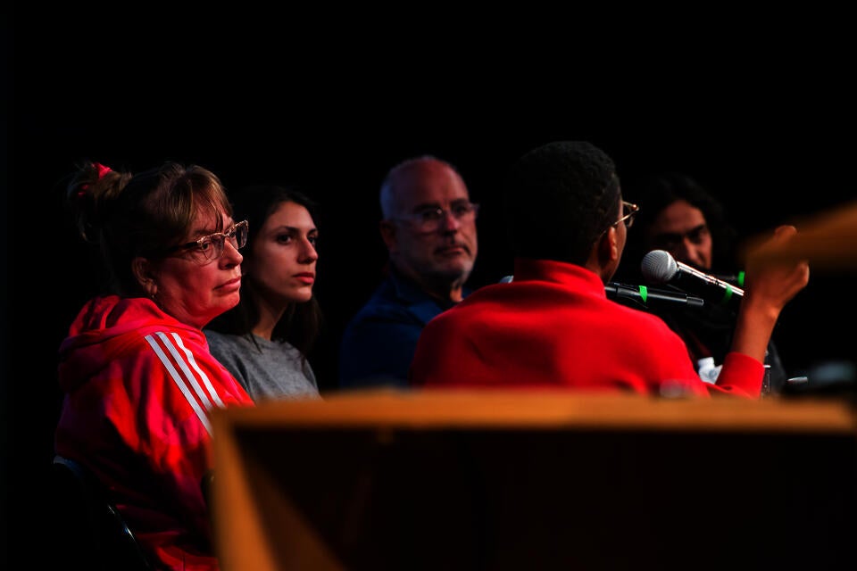 Close-up angled shot of five panelists dressed in bright colors.