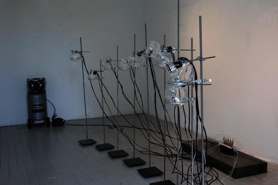 Side shot of sculpture with air compressor in background.
