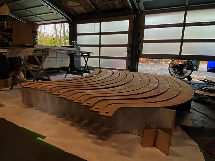 A garage with several curved wooden panels laying next to each other ready to be finished