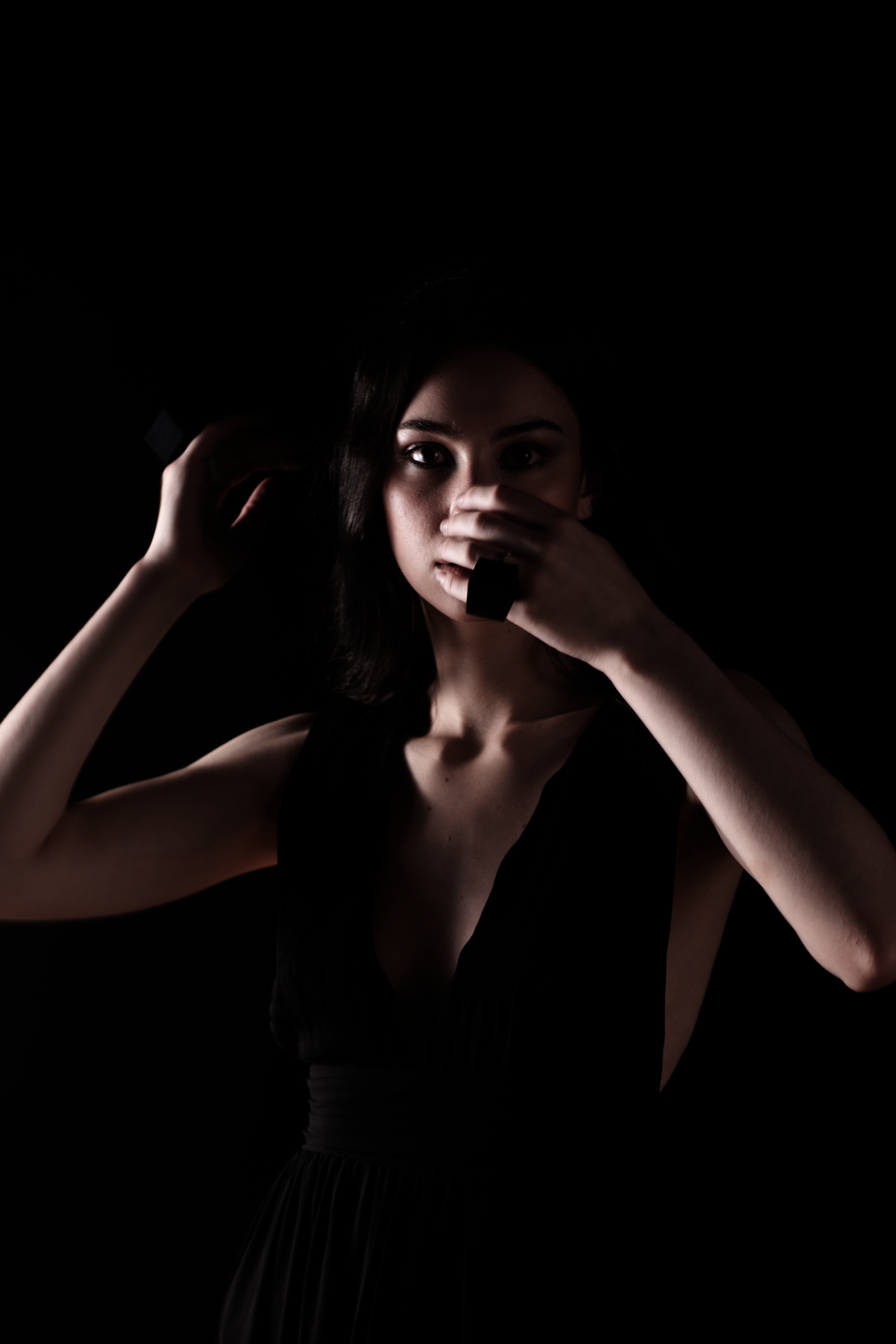 Model is wearing two rings and covering her face with her hands.