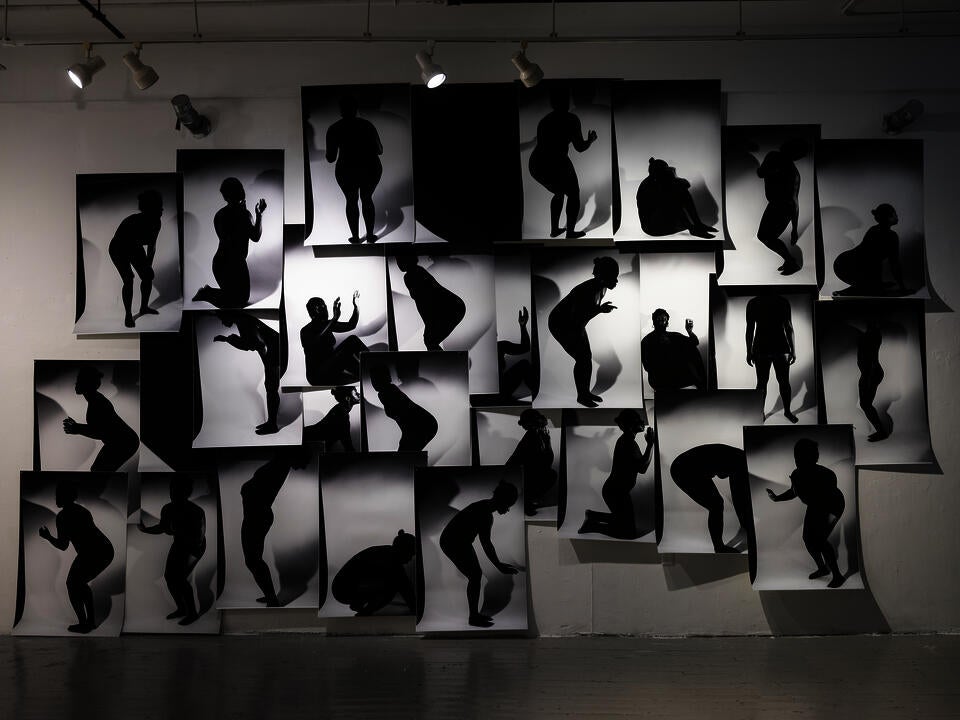 a massive collage on a wall with black and white silhouette images