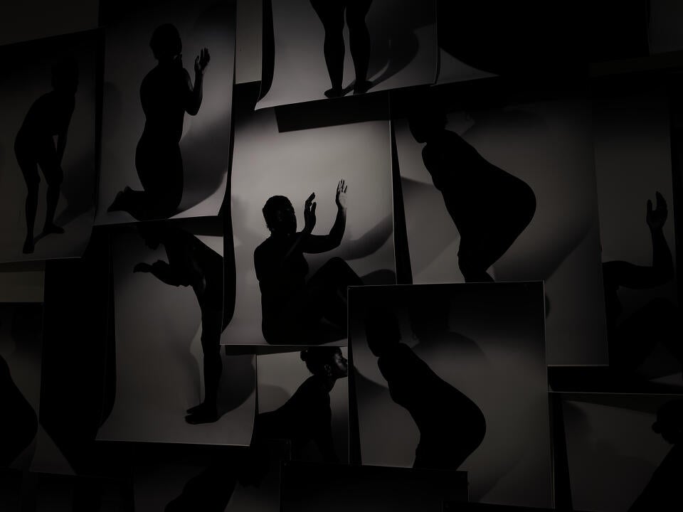 a massive collage on a wall with black and white silhouette images