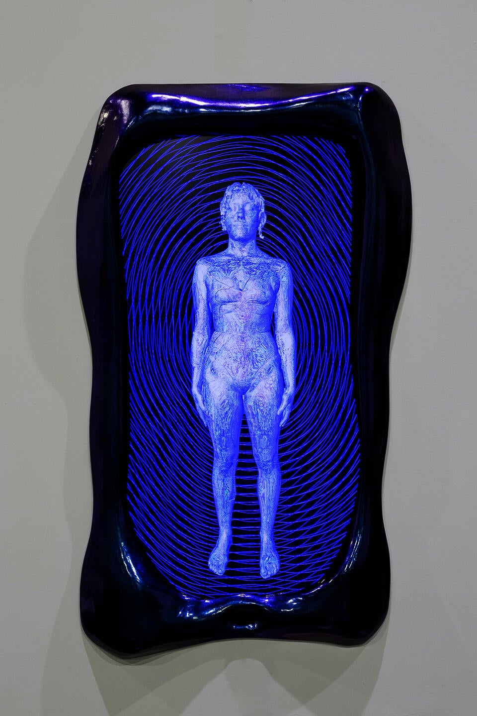 A blue and purple frame surrounds a screen showing a cyborg like figure
