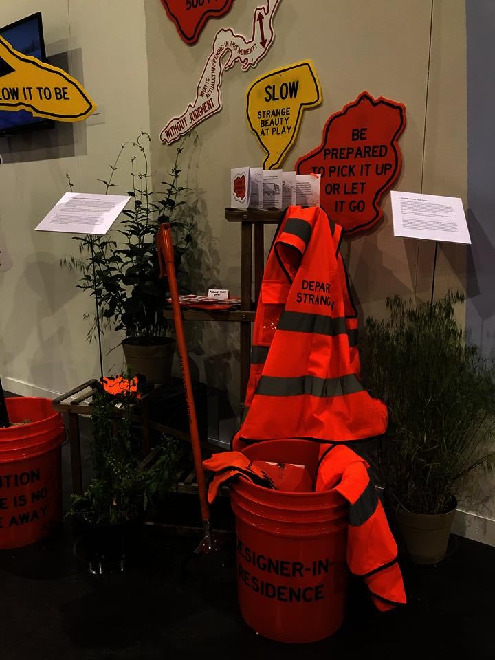 Installation view of a Designer-in-Residence Toolkit, including bucket, trash grabber, vest, pamphlet, clipboard, stickers, and gloves