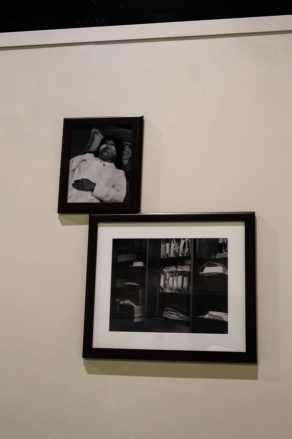 Color pigment print of a suitcase of busts mounted and bisected in a wall corner