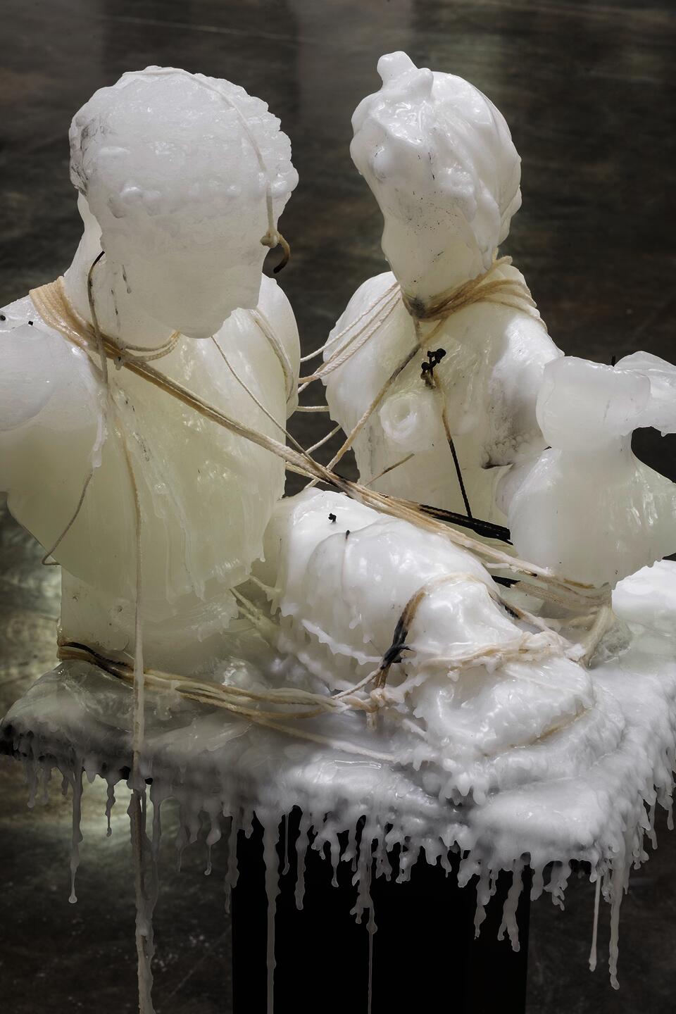 Detail of sculpture wax figures arranged and entangled with wicks.