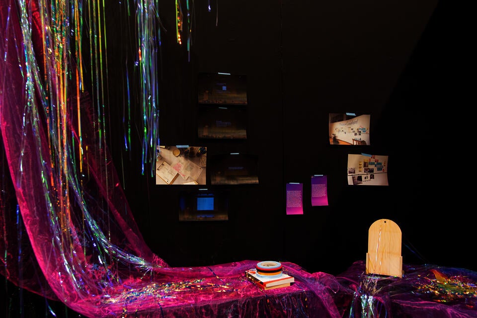 iridescent sheer Fuschia with blue organza, iridescent vinyl party streamers, photo documents and Instagram stories printed on paper, artist tapes, 'Cruising Utopia' by José Esteban Muñoz 'All About Love: New Visions' by bell hooks, and wooden board.