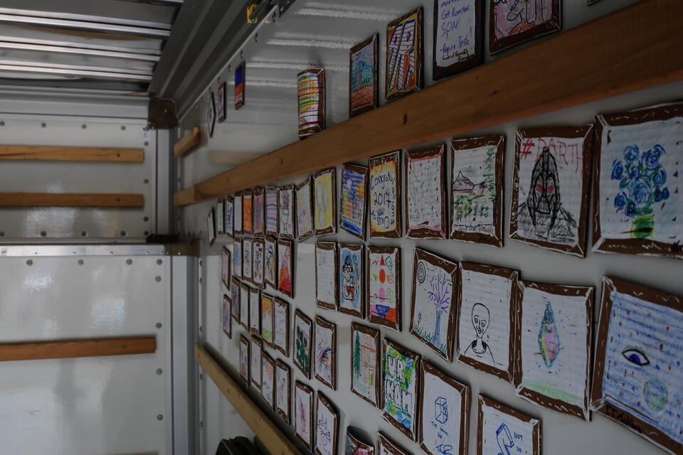 Inside of U-haul Truck covred with small pieces of cardboard that have drawings on them. 