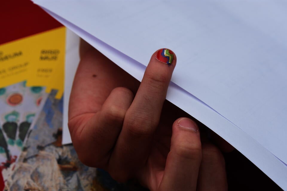 Someone holding out a finger out to display a single fingernail design from the makeover U-haul truck. 