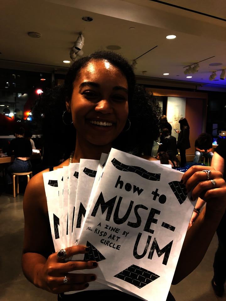 Teenager holding zines about the museum design by RAC