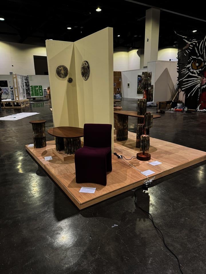 A modern furniture collection includes a coffee table, console table, pedestal table, and two floor lamps. The tables have an aluminum base and walnut tops. The floor lamps display decorative aluminum shades and central walnut stands.