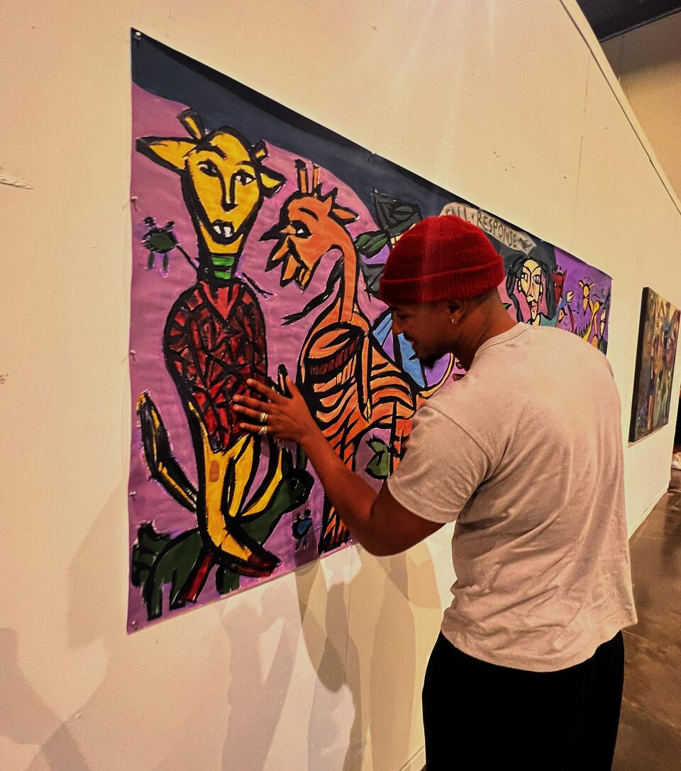 a person with a red hat touching the painting