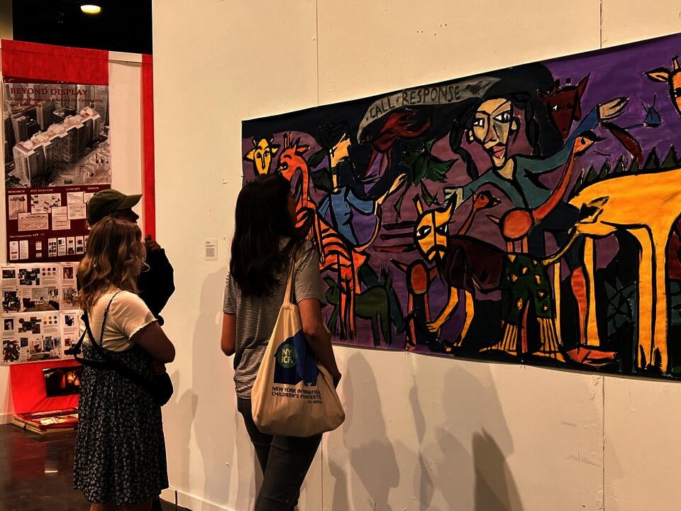 two individuals looking at a painting