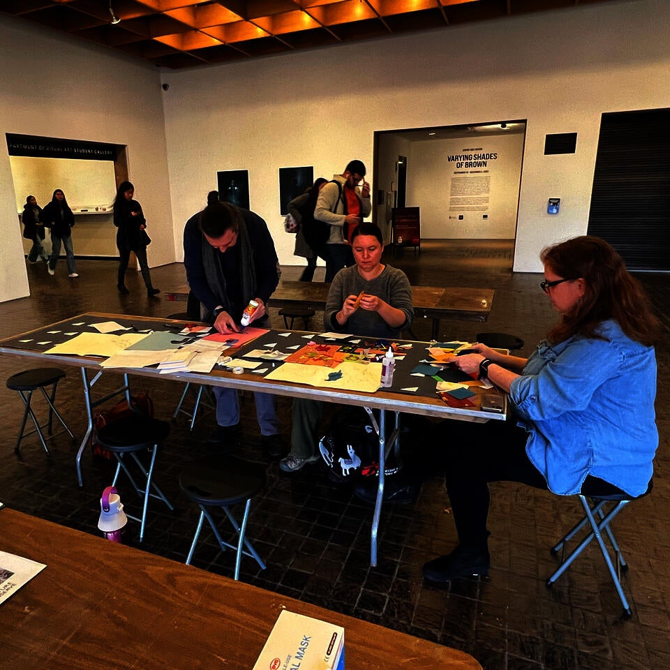 Participants of the workshop work around a table on a collaborative Illustration