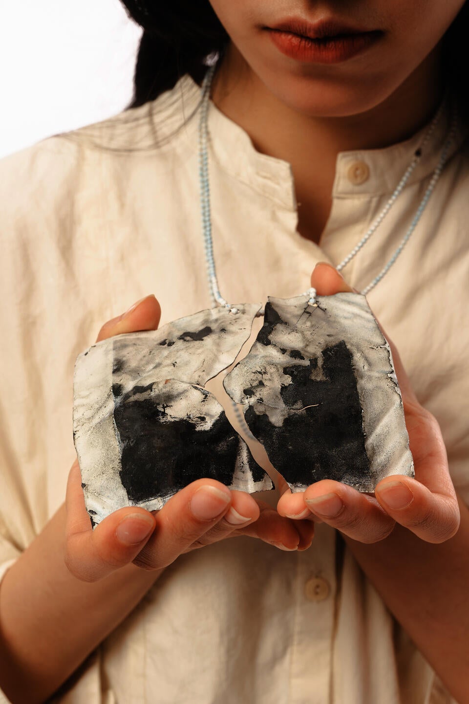 2 pendants hold in hands, forming a black image as a whole. 