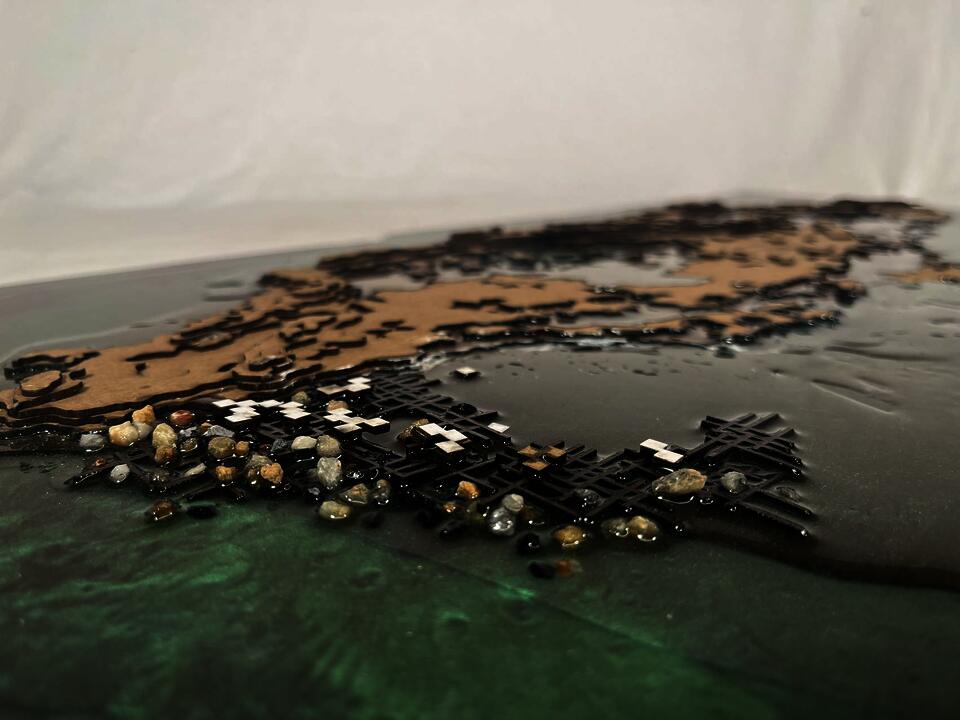 A model made of clipboard and resin showing the physical relationship between original island and future construction.