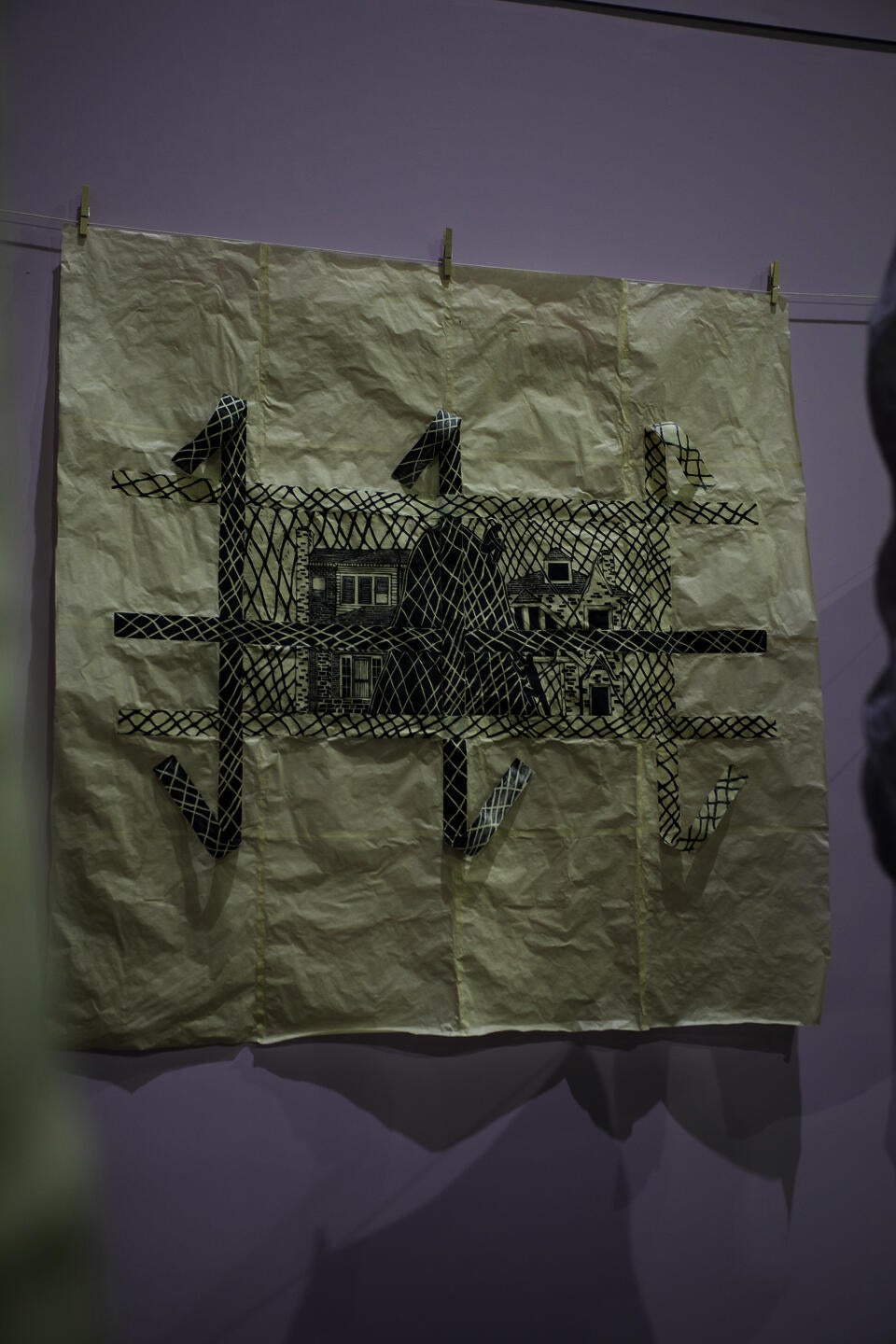 Image of large, collaged, purple, print depicting two houses being divided by a mountain. 