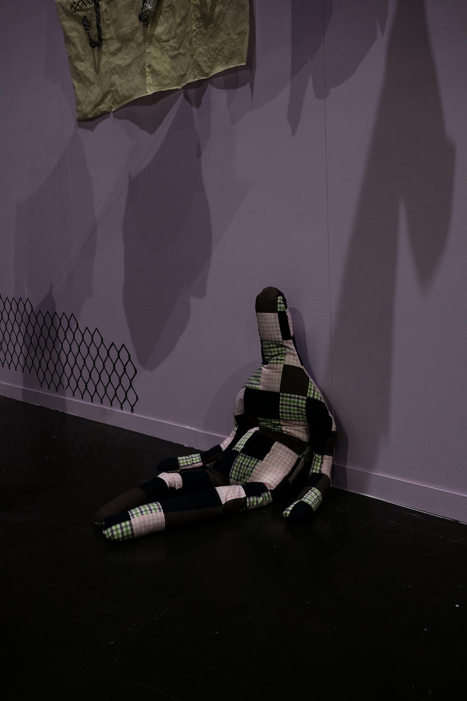 image of quilted stuffed human-like doll, sitting on the floor hunched over