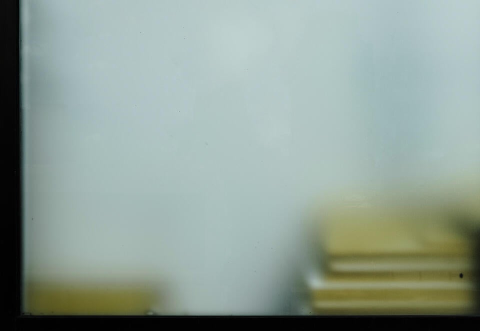 A window from an office with yellow documents stack.
