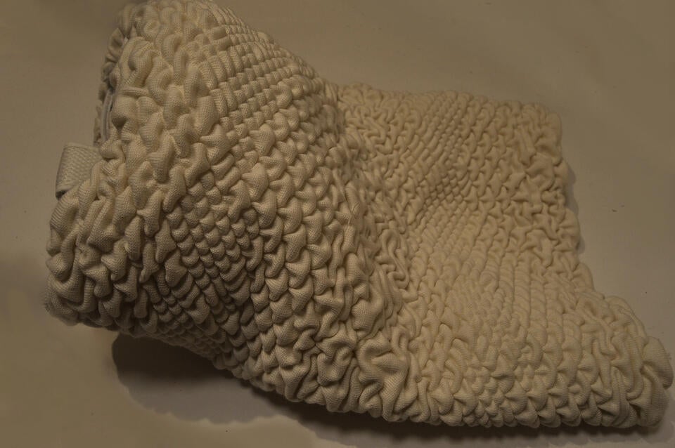 A knitted helmet accessory, inspired by the VR headset but alternatively covering vision and hearing and instead allowing for the wearer to be immered in the haptics.