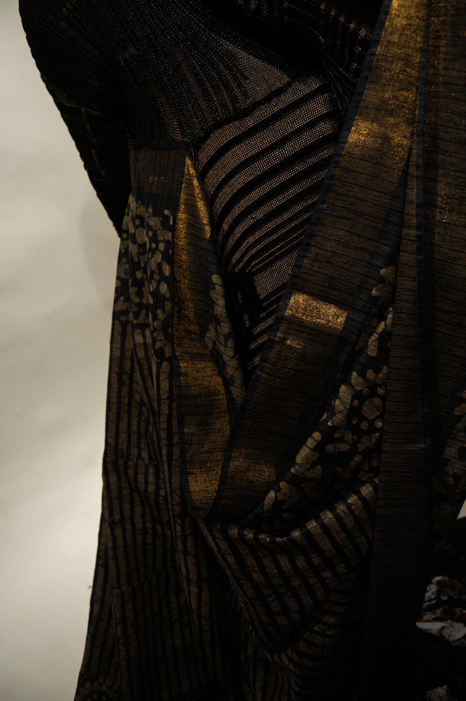 The details of the pleated sari communicate with the rib structure of the knit fabric.