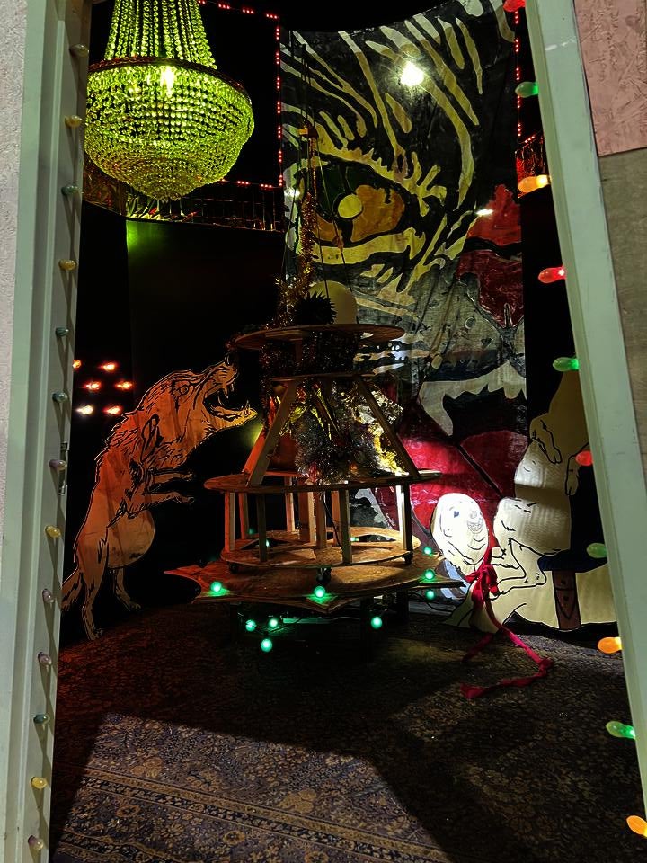 A large room with a painted fabric black cat is covering the front. When you walk around the back, there is an entrance... inside it looks like the aftermath of a bizarre party.