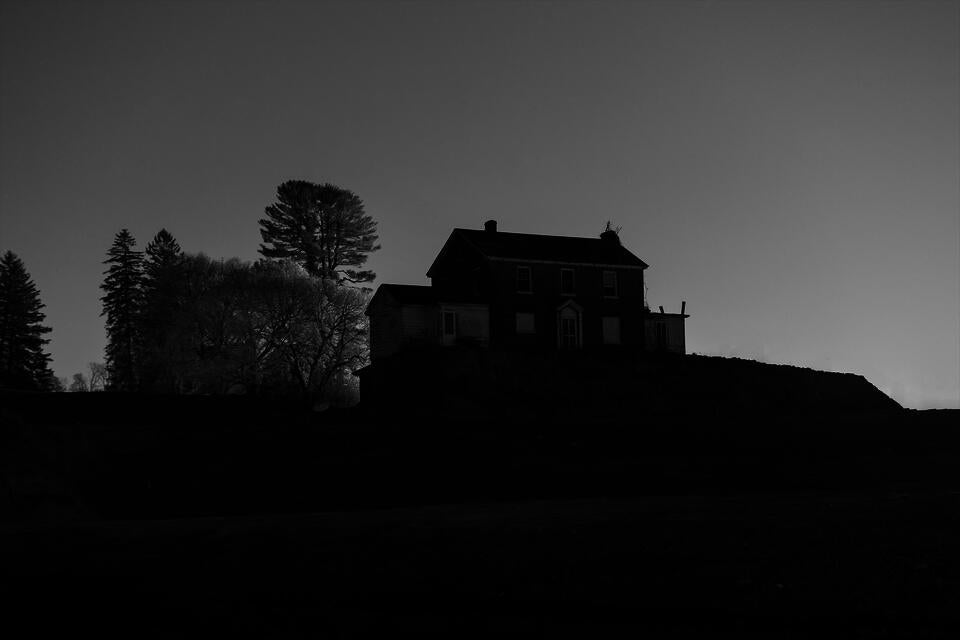 An old abandoned house surrounded by a dug out constuction site