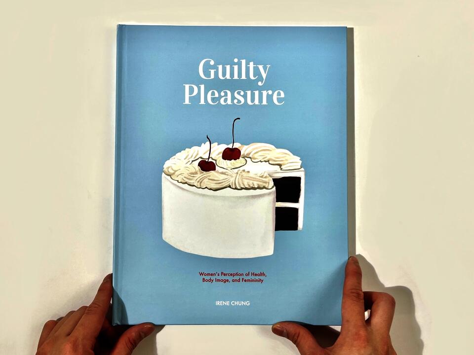 A photograph of the book cover, which features a creamy white cake with cherries on top, sitting on a baby-blue background