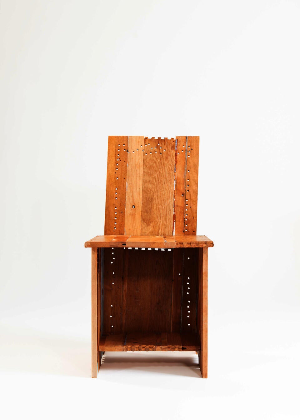 A chair made from the deconstructed materials of a found dresser painted in multiple colors.