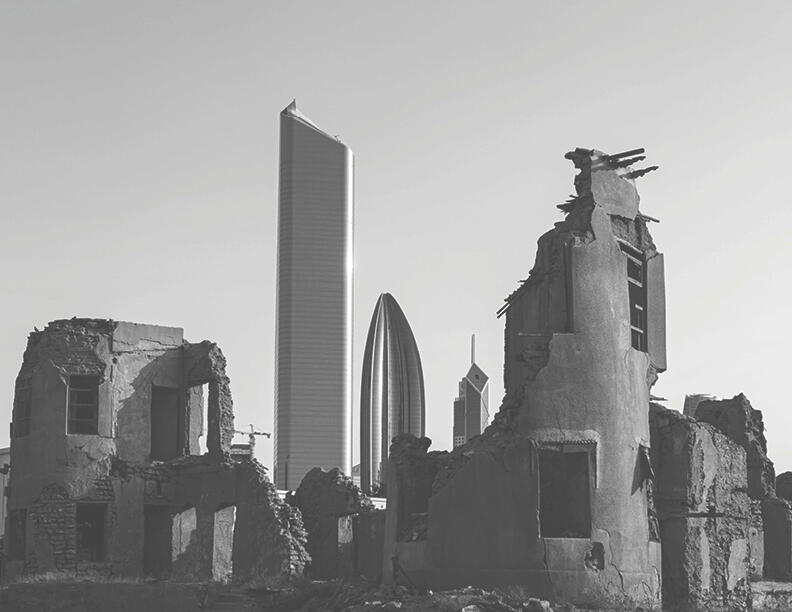 Black and white image of building in ruins, set against the back drop of the Kuwait city skyline.