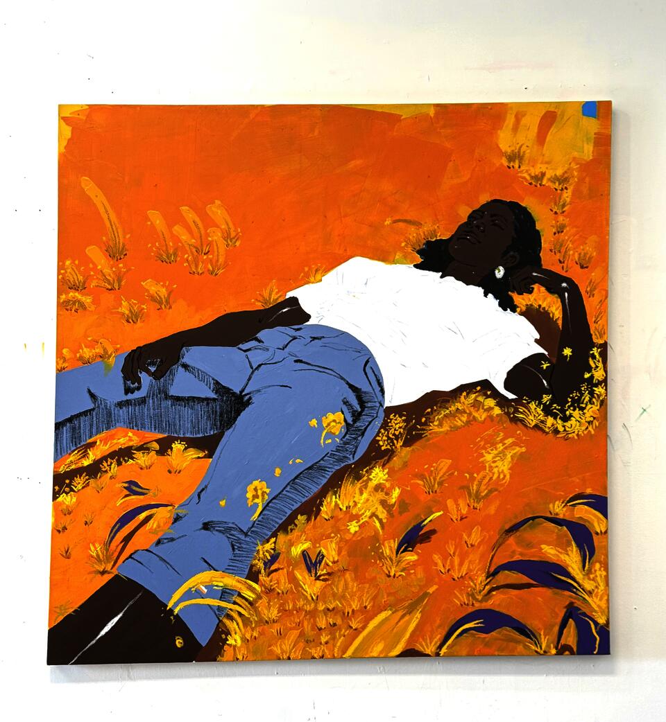 A Black woman lying in a golden field, surrounded by yellow and purple foliage, wearing a white t-shirt and light blue jeans.