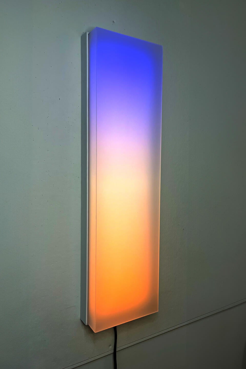 Four foot tall panel of light that shows a slow moving gradient and white lights that dance across