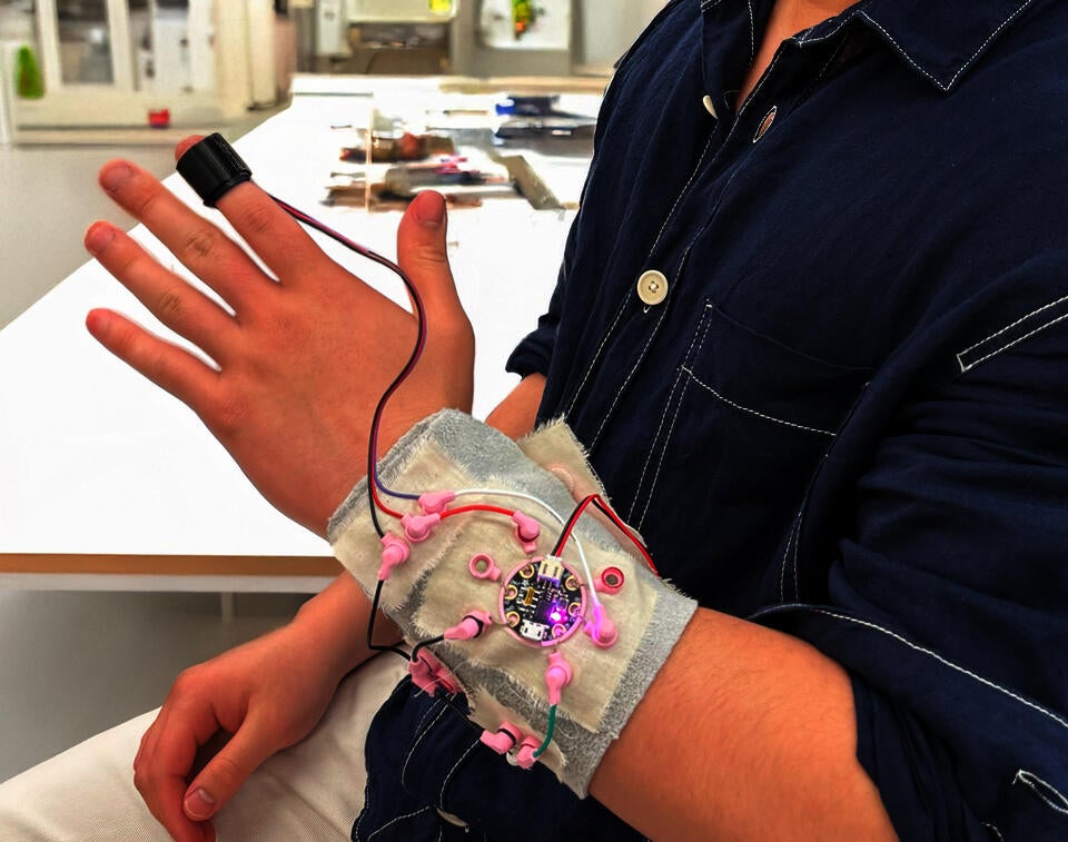 Electronic components on fabric wrapped around outstretched hand to created haptic pulse sensor prototype