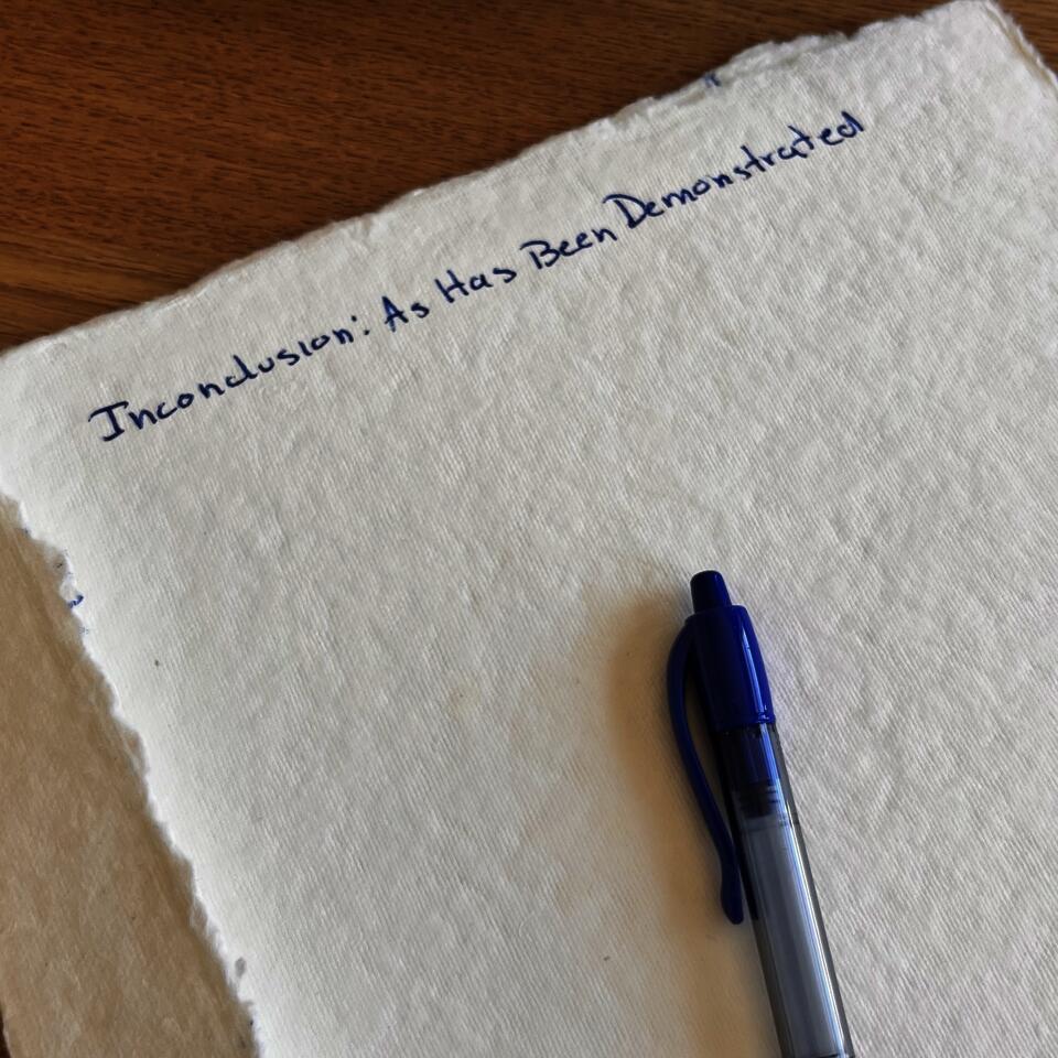 Cream paper with rough edges lies mostly blank on a wooden table beside a blue pen. Blue handwritten title at the top reads, “Inconclusion: As Has Been Demonstrated.