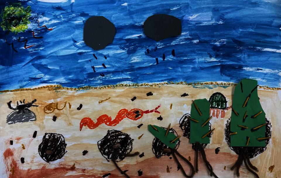 This is a painted/ collaged diagram of the germination cycle of a cactus. It is made of construction paper, toothpicks for the cactus spikes and kidney beans for the seed and yarn for the roots.
