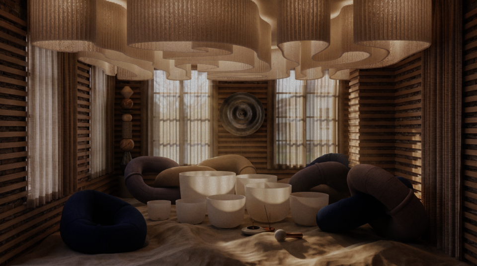 A rolling sand floor fills a meditative space lined with slatted wooden walls. Below a billowing, fabric ceiling, white crystal singing bowls sit amongst plush, ring-shaped floor sofas in blue and beige.